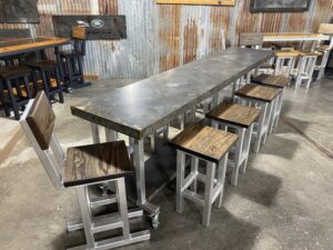Metal worktable accompanied by stools are on display