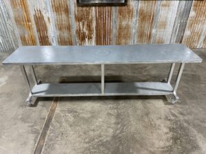 A long Galvanized series worktable is on display